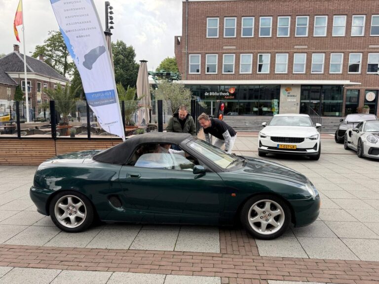 Een groene MG cabrio wordt klaargemaakt voor de start