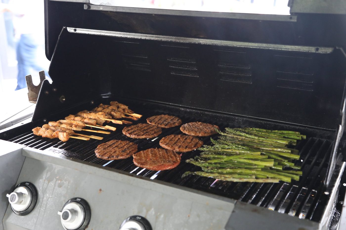 Spiesen, burgers en groene asperges op de barbecue